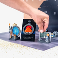 Hand opening a door of the BlueBrixx Stargate 1994 Advent Calendar, finished builds in front